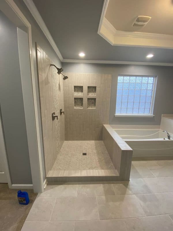 Spacious modern bathroom featuring a walk-in shower, tub, and elegant tile design.