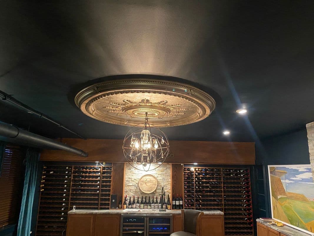 Elegant wine cellar featuring intricate ceiling design and decorative chandelier.
